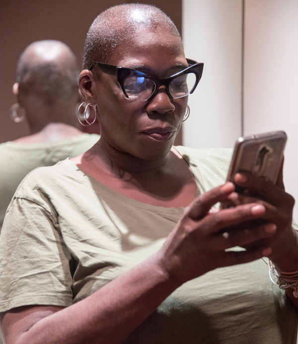 A woman looks down on her cell phone.