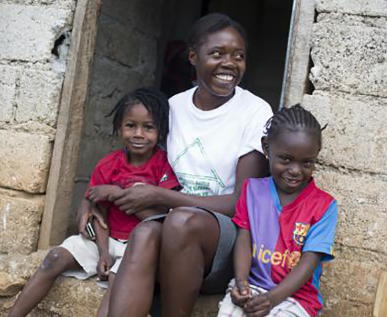 Ketcia, a community health worker, sits with children during a PEPFAR-sponsored home health care visit in Robin, Haiti.