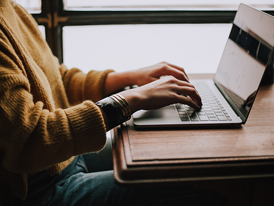 Close of photo of hands typing on a laptop. 