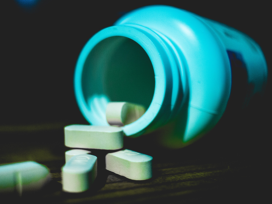 Dramatic close up image of a spilled bottle of pills. 