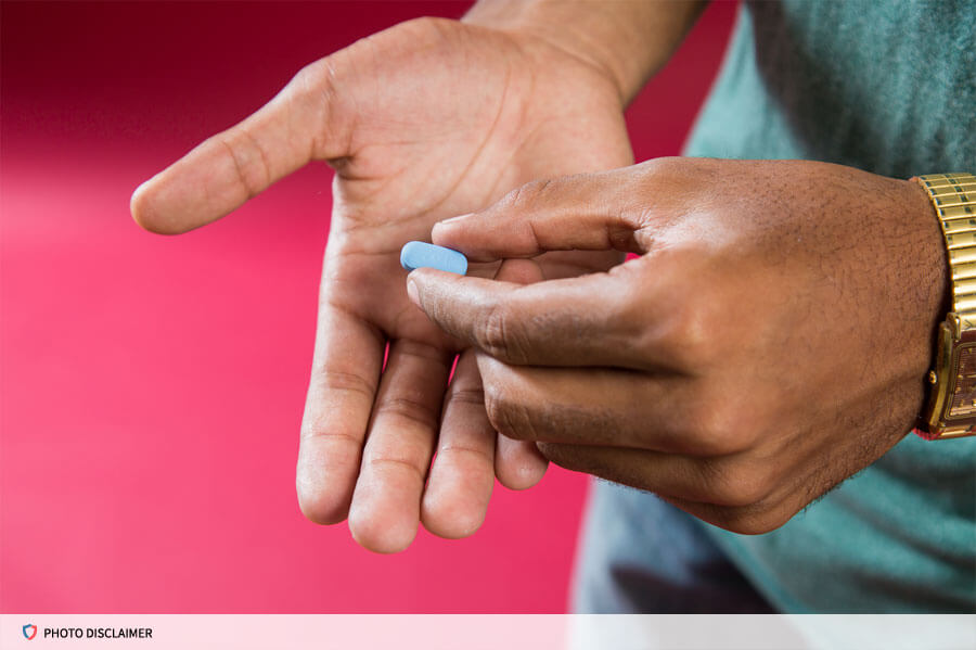 Hand holding a pill above an open palm