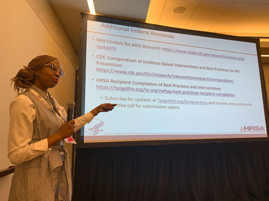 A presenter speaking in front of a projection at a HRSA session at USCA 2019.