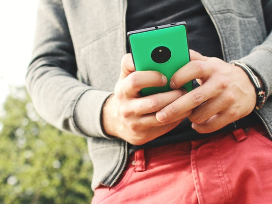 man holding green cell phone checking his email