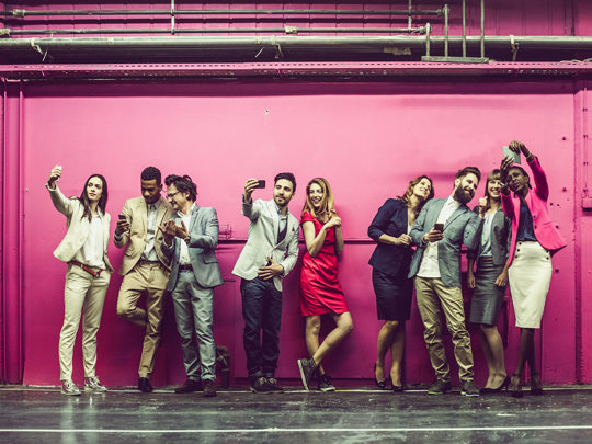 A group of people take selfies against a purple background.